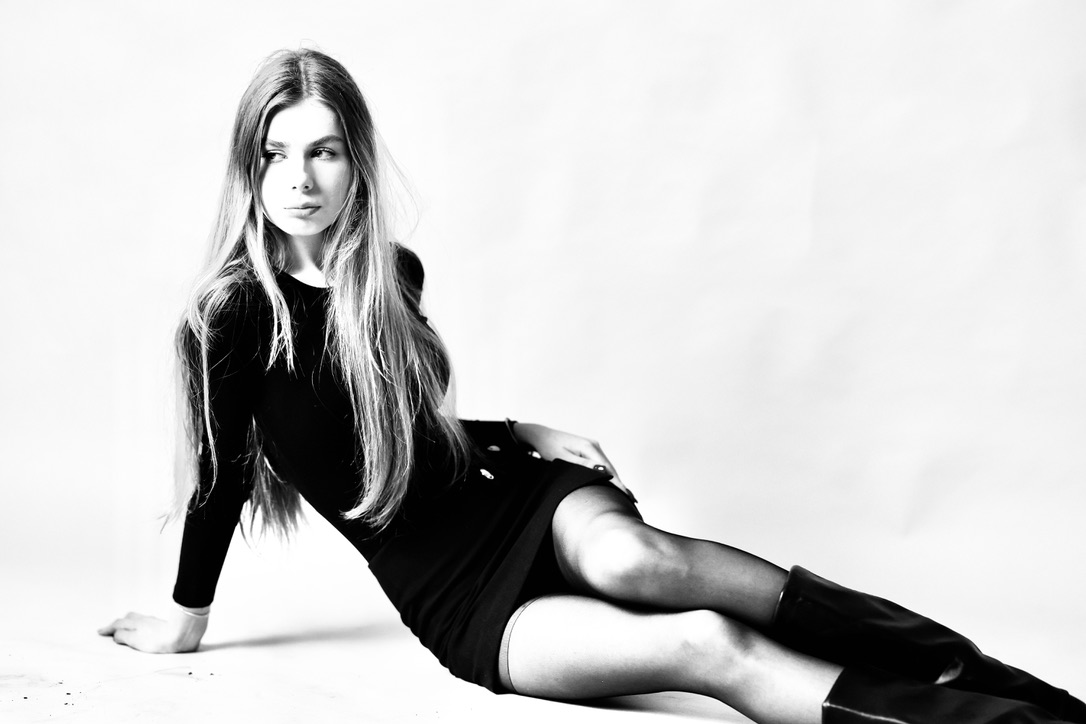 Black and white fashion editorial, reclining pose in mini dress