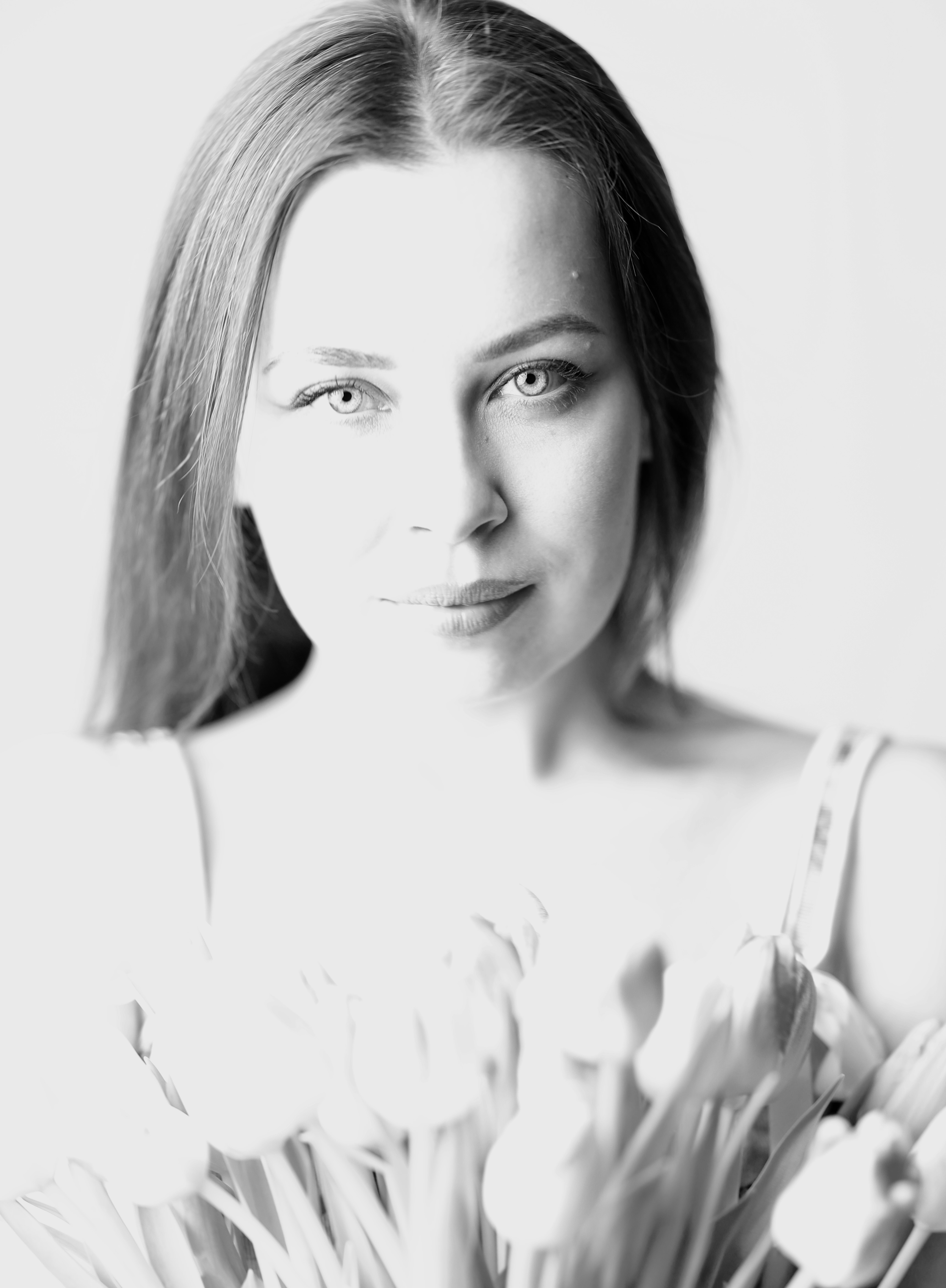 High-key portrait with tulips, gentle direct gaze